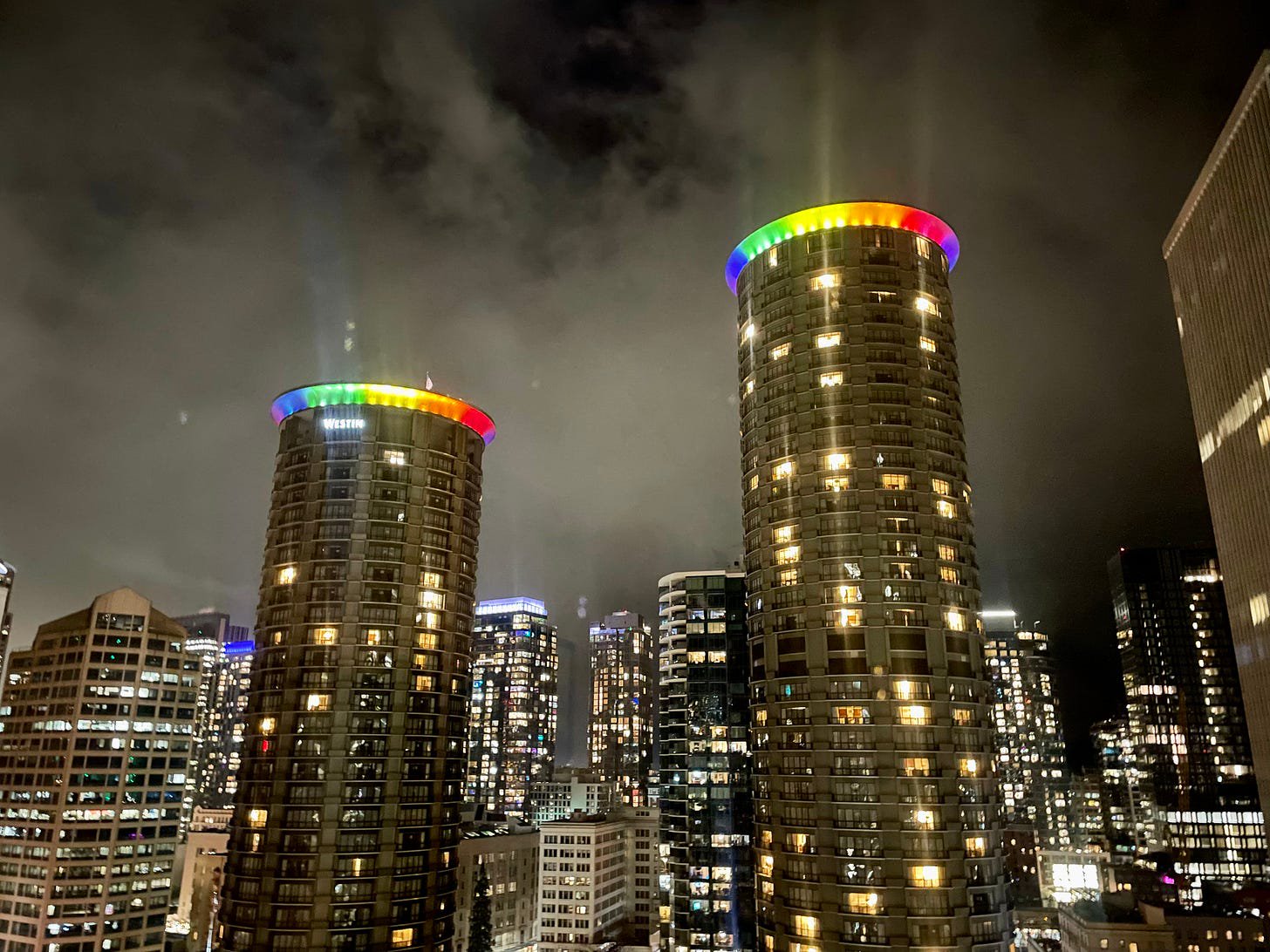 [ Rainbow lights blazing through the night sky wrapping the tops of the Westin Hotel twin towers in downtown Seattle on a cold, icy night ]