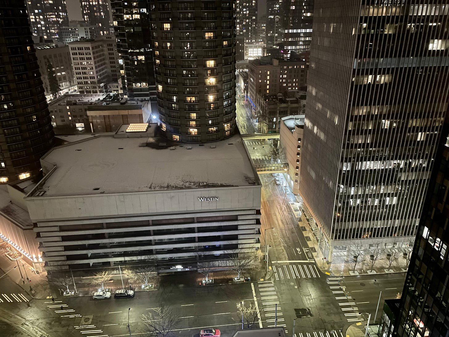 [ A snow-topped Westin Hotel and light-reflecting damn streets in downtown Seattle ]